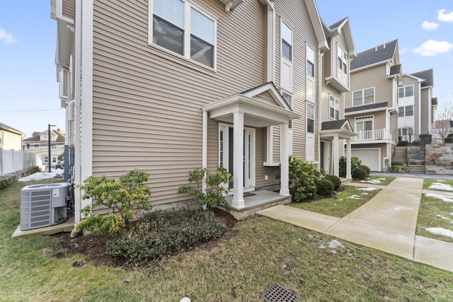 view of front of house with a residential view, central AC, driveway, and an attached garage