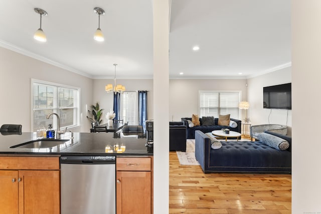 kitchen featuring a sink, light wood-style floors, ornamental molding, dishwasher, and dark countertops