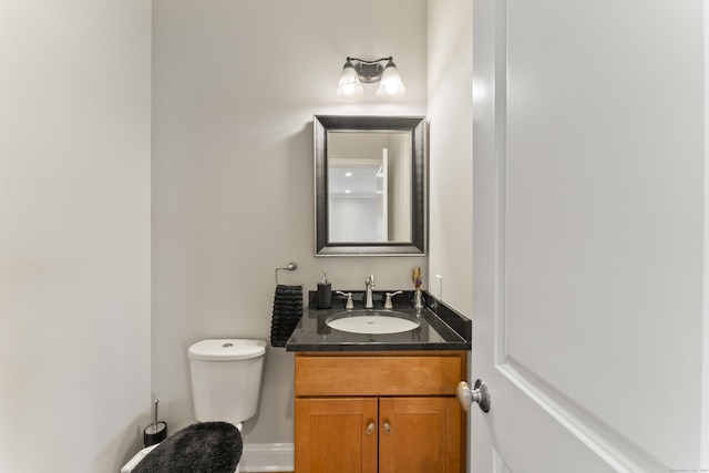 half bathroom featuring toilet and vanity