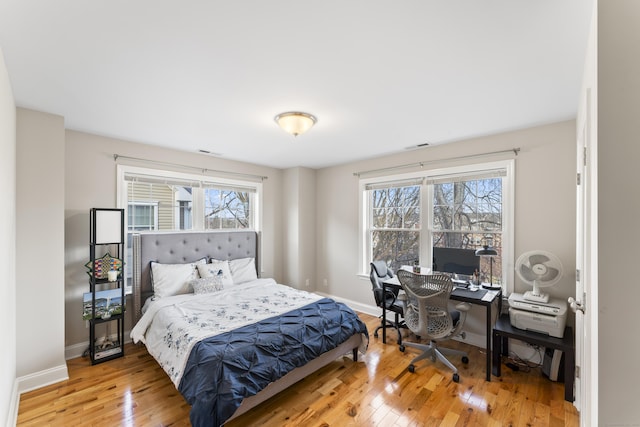 bedroom featuring hardwood / wood-style flooring, visible vents, and baseboards