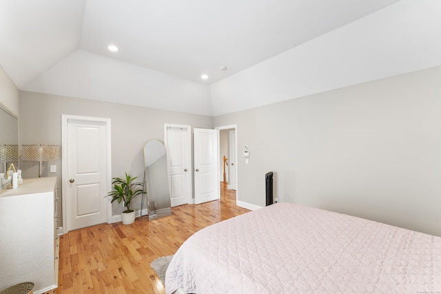 bedroom featuring light wood-style floors, baseboards, vaulted ceiling, and recessed lighting