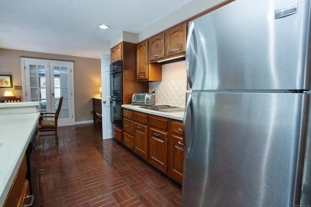 kitchen featuring french doors, black appliances, a textured ceiling, and backsplash