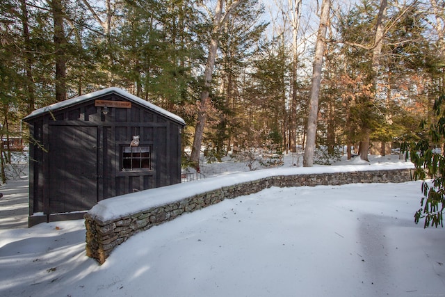 snowy yard featuring a storage unit