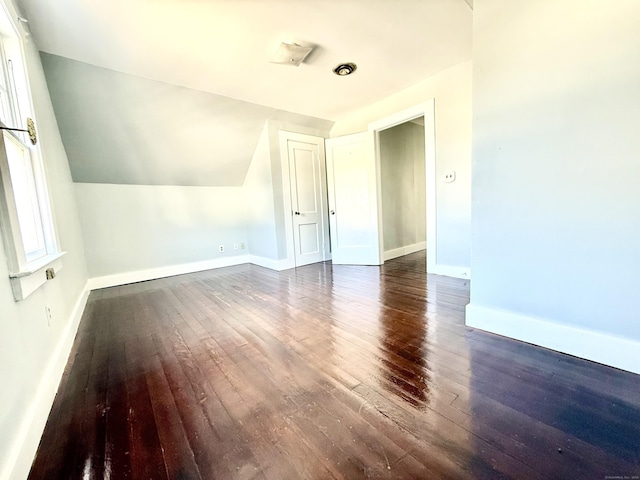 bonus room with lofted ceiling and dark hardwood / wood-style floors