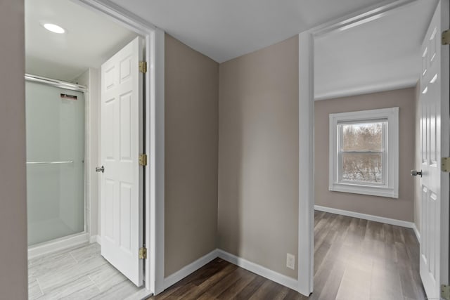 hall with baseboards and wood finished floors