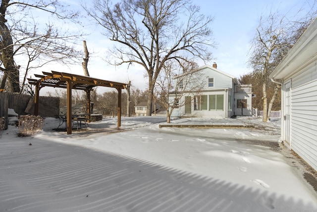 yard layered in snow with fence and a pergola