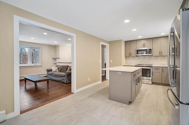 kitchen with tasteful backsplash, a center island, stainless steel appliances, and gray cabinets