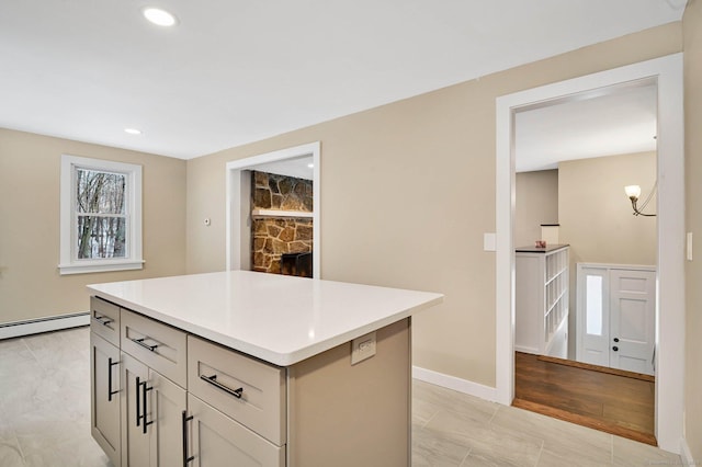 kitchen featuring gray cabinets, a center island, and a baseboard heating unit