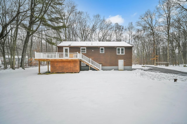 snow covered property with a wooden deck