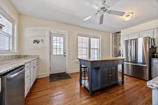 kitchen with white cabinets, a breakfast bar, a kitchen island, and stainless steel appliances