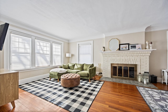 living room featuring ornamental molding, a brick fireplace, and wood finished floors