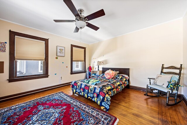 bedroom featuring ceiling fan, crown molding, baseboards, and wood finished floors