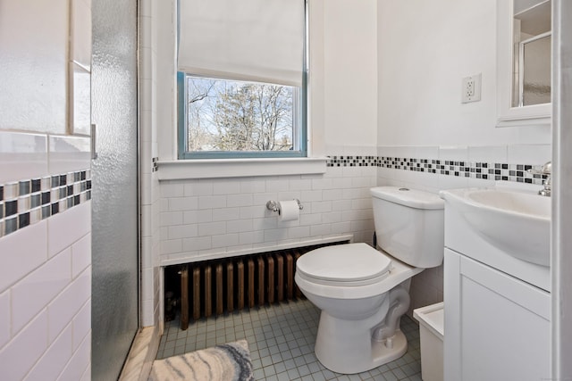 full bath featuring toilet, tile patterned floors, vanity, a shower stall, and tile walls