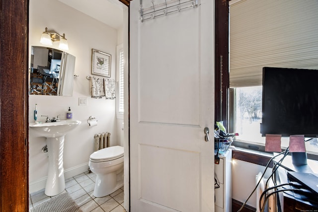 full bathroom featuring baseboards, toilet, radiator, tile patterned floors, and a sink