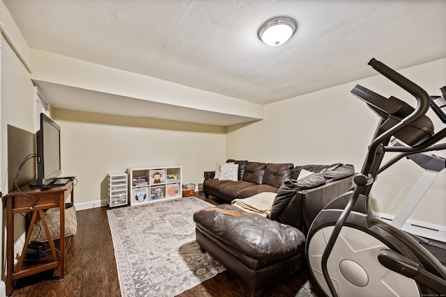 living room featuring a textured ceiling, dark wood-type flooring, and baseboards