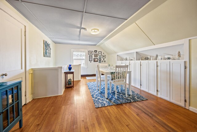 dining area featuring lofted ceiling and wood finished floors