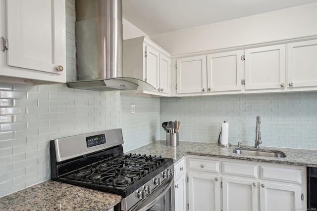 kitchen with wall chimney range hood, gas range, decorative backsplash, white cabinetry, and a sink