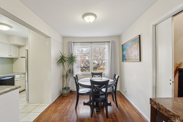 dining space featuring light wood-style floors and baseboards