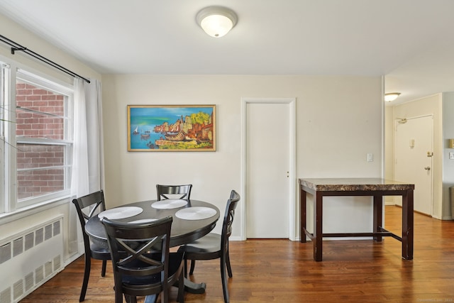 dining space featuring radiator heating unit and wood finished floors