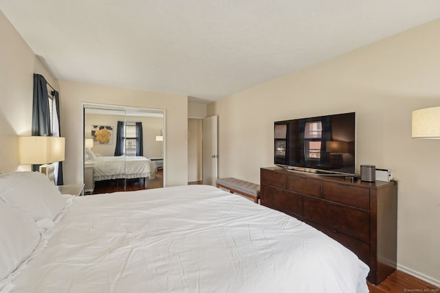 bedroom featuring a closet, baseboards, and wood finished floors