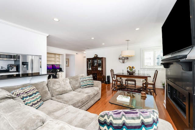 living room with ornamental molding and light hardwood / wood-style flooring