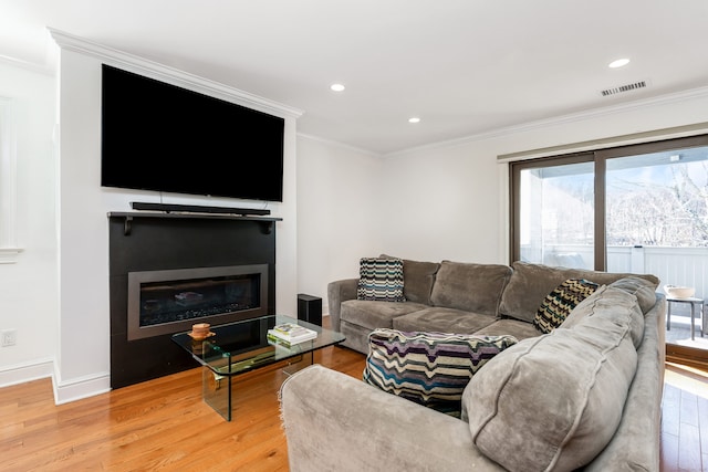 living room with hardwood / wood-style floors and crown molding