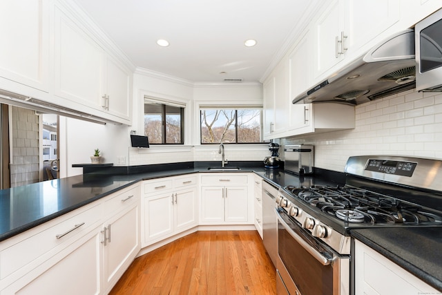 kitchen featuring light hardwood / wood-style flooring, sink, backsplash, white cabinetry, and stainless steel appliances