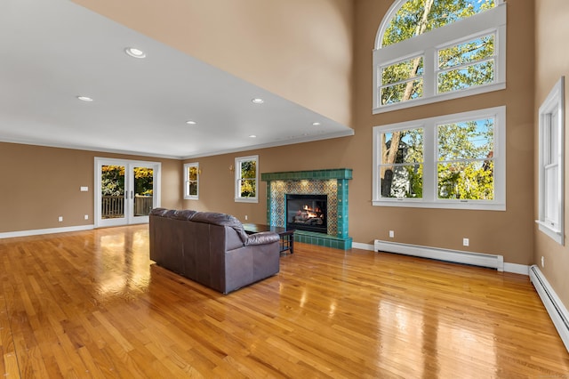 unfurnished living room featuring baseboard heating, plenty of natural light, and french doors