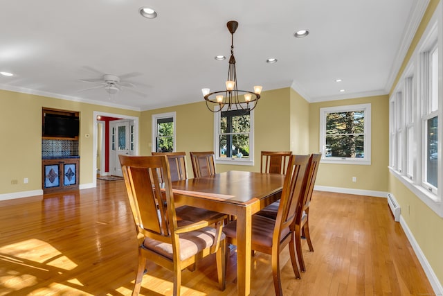 dining area with ornamental molding, a healthy amount of sunlight, baseboard heating, and light hardwood / wood-style flooring