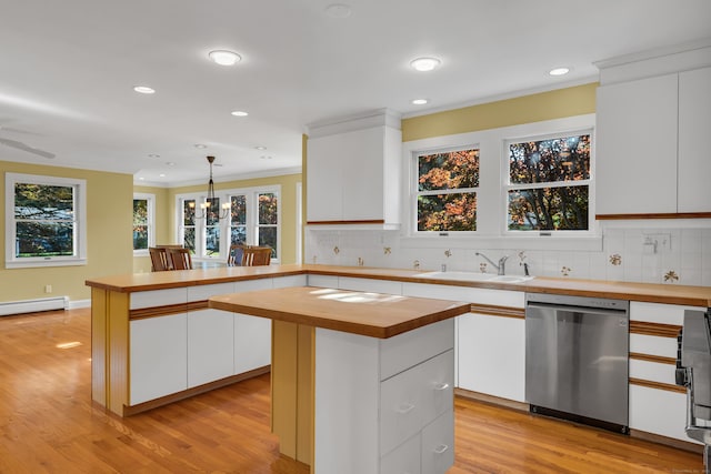 kitchen with dishwasher, sink, hanging light fixtures, and white cabinets