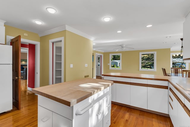 kitchen featuring light hardwood / wood-style floors, a center island, white cabinets, and white refrigerator