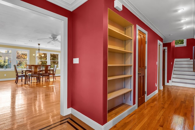 hallway featuring ornamental molding, wood-type flooring, and a notable chandelier