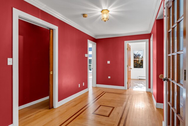 interior space with crown molding, wood-type flooring, and baseboard heating