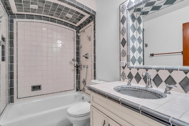 full bathroom featuring tiled shower / bath combo, vanity, and toilet