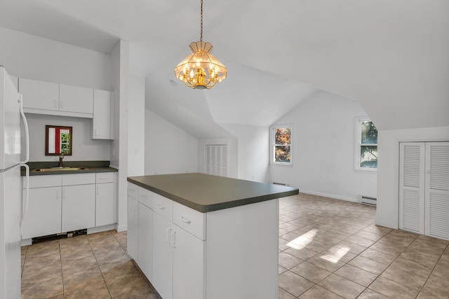 kitchen featuring sink, white refrigerator, white cabinets, pendant lighting, and a baseboard heating unit