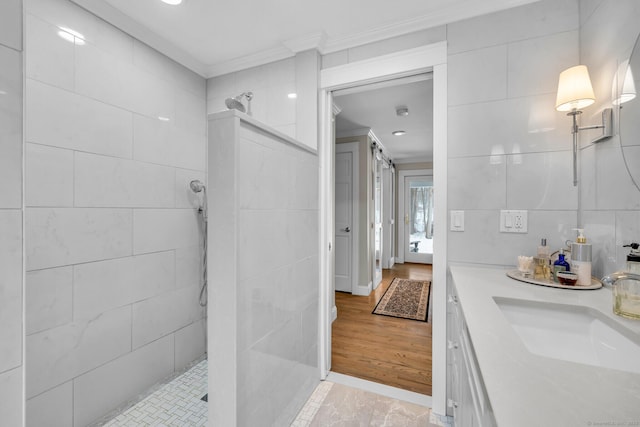 full bath featuring ornamental molding, walk in shower, vanity, and tile walls