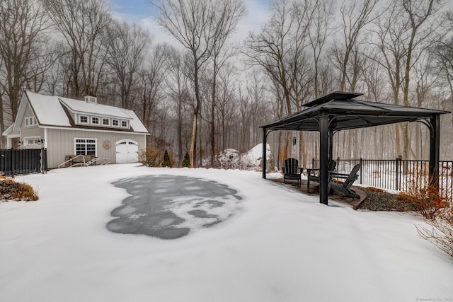 snowy yard with a gazebo, an outdoor structure, and fence