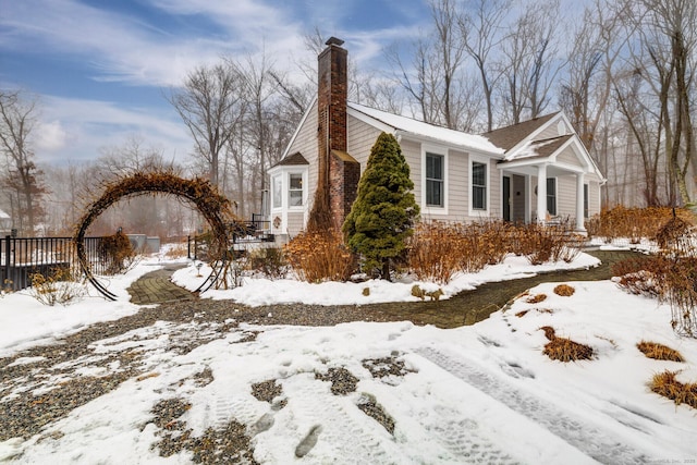 snow covered property featuring a chimney