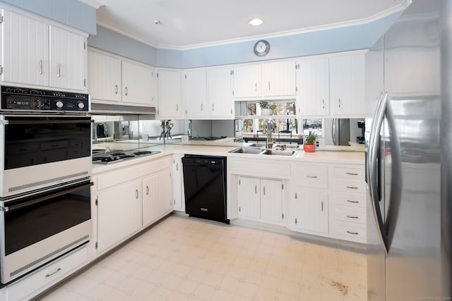 kitchen with a sink, black dishwasher, light countertops, freestanding refrigerator, and stovetop