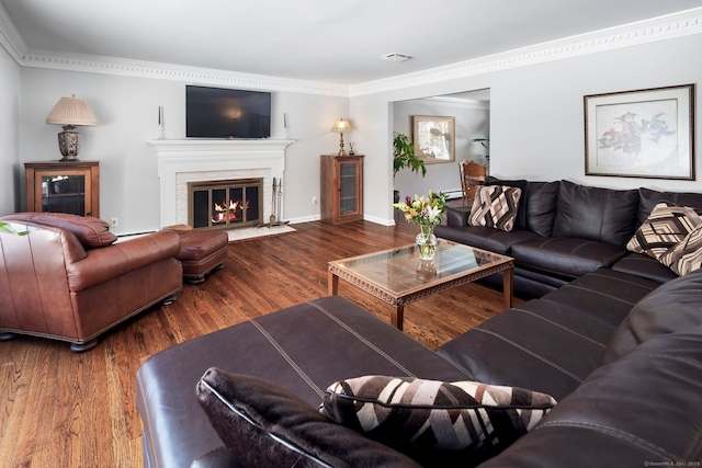 living area with visible vents, baseboards, a high end fireplace, dark wood finished floors, and crown molding