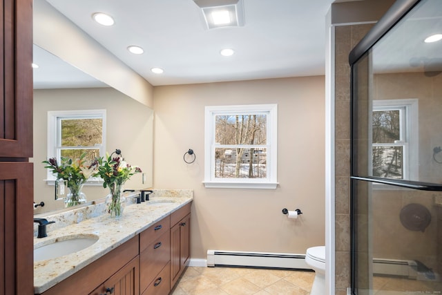 bathroom with toilet, a sink, baseboard heating, and tile patterned floors