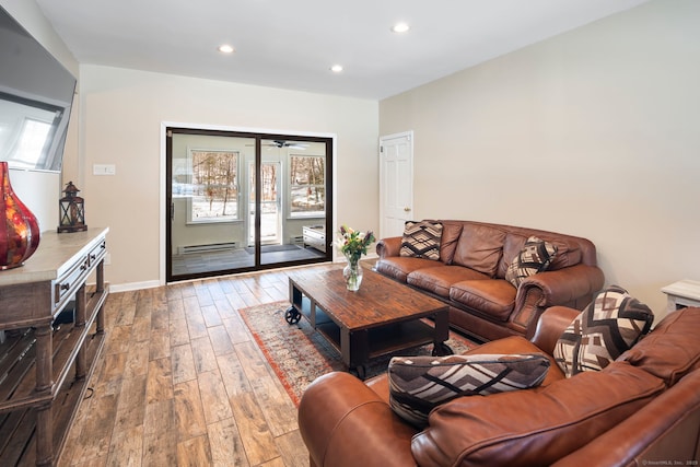 living area featuring baseboards, wood finished floors, and recessed lighting