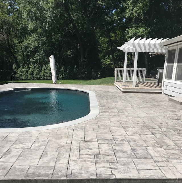 pool with a patio and a pergola