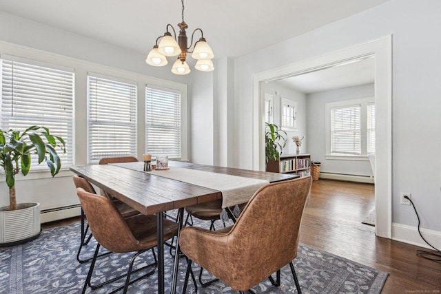 dining area featuring an inviting chandelier, dark hardwood / wood-style floors, and a baseboard heating unit