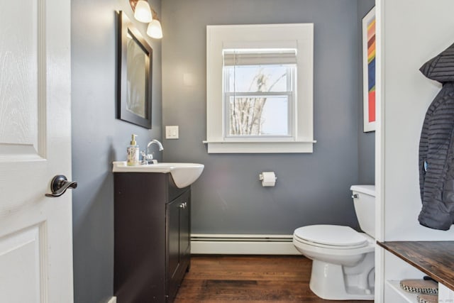 bathroom with vanity, a baseboard heating unit, wood-type flooring, and toilet