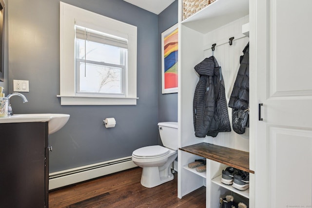 bathroom featuring vanity, toilet, hardwood / wood-style floors, and a baseboard heating unit