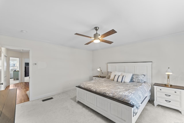 carpeted bedroom with ornamental molding and ceiling fan