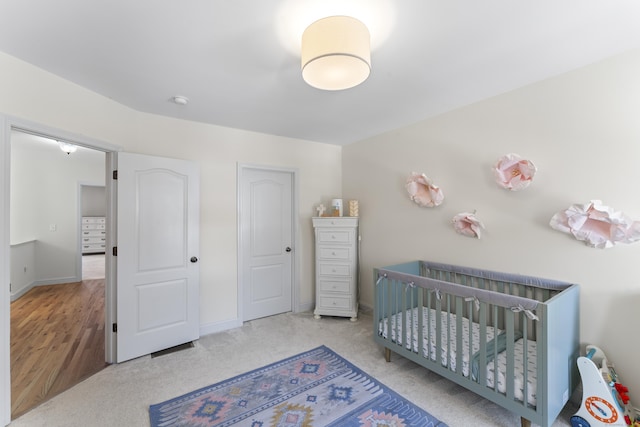 bedroom with a crib and carpet flooring