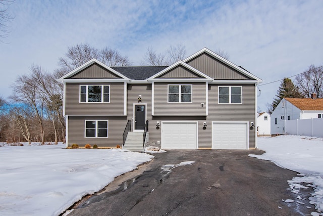 split foyer home with aphalt driveway, board and batten siding, and a garage