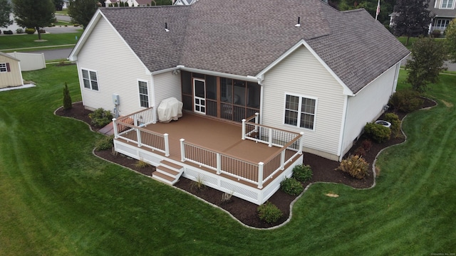 back of property with a yard, a deck, and a sunroom